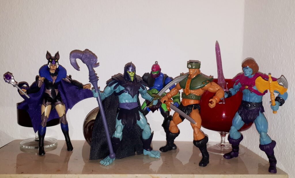 Skeletor holds Tri-Klops at sword point, while Trap Jaw, Faker and Evil-Lyn look on.