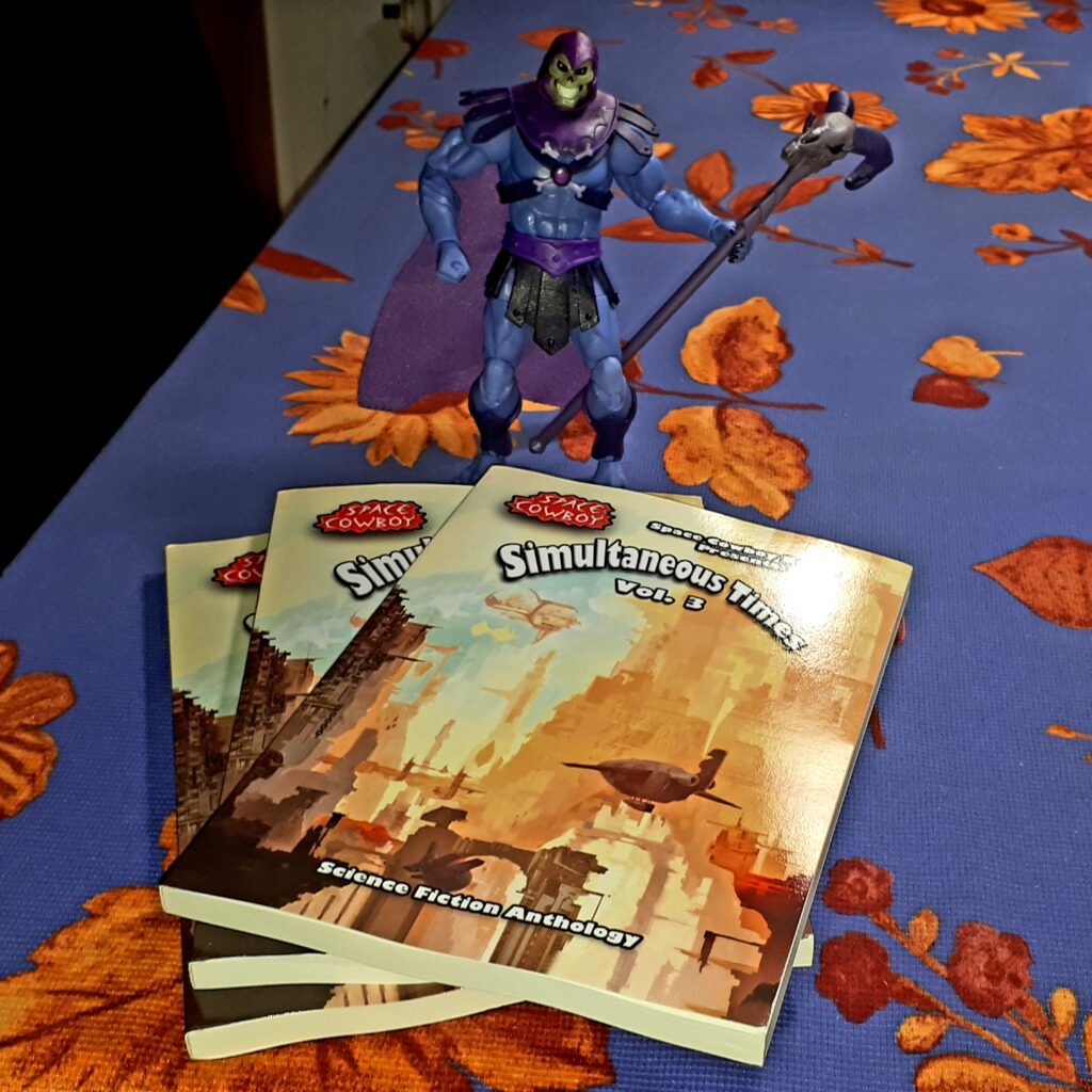 Skeletor poses with contributor copies of Simultaneous Times Volume 3.