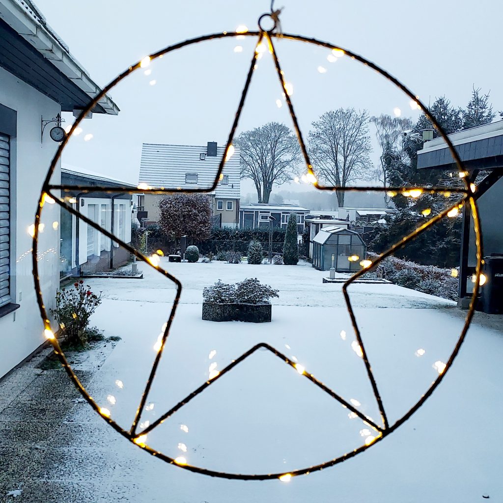 Illuminated Christmas star decoration with snow