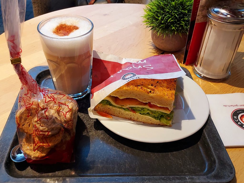 Latte macchiato, cookies and tomato mozarella sandwich